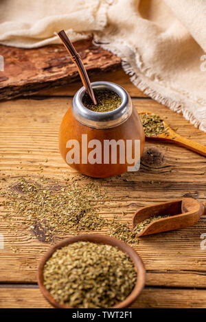 Yerba Mate Blätter und Tee mate in der kalebasse mit Bombilla auf einer hölzernen Hintergrund Stockfoto