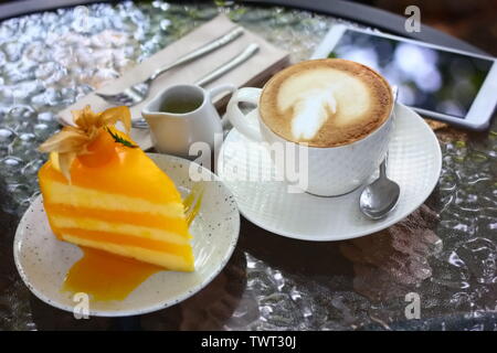 Heiße ende Kunst mit orange Kuchen im Cafe Stockfoto