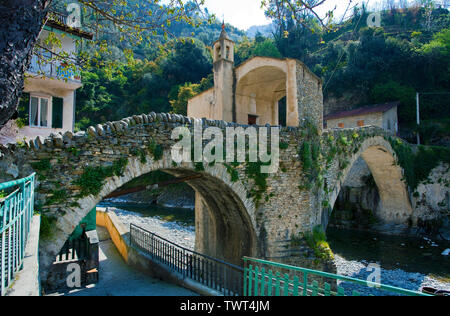 Alte mittelalterliche steinerne Brücke mit Brücke Kapelle in Badalucco, Dorf in der Provinz Imperia, Riviera di Ponente, Ligurien, Italien Stockfoto