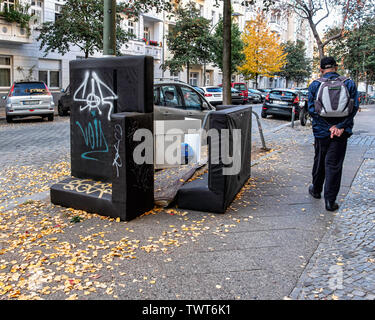 Älterer Mann mit Rucksack Wanderungen vorbei an verlassenen Möbel auf Pflaster in Friedrichshain, Berlin Stockfoto