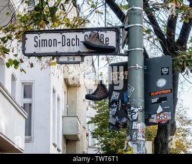 Stiefel hängen an Simon Dach strasse Straßenschild in Friedrichshain-Berlin Stockfoto