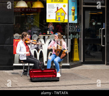 Zwei junge Mädchen Straßenmusik auf der Hohe Straße in der Stadt Galway Stockfoto