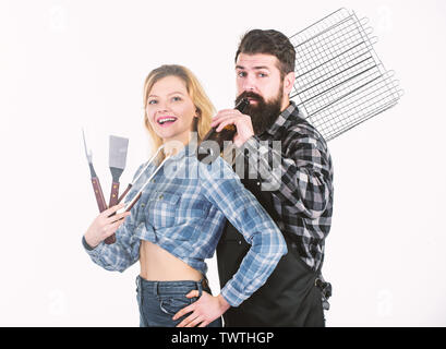 Trinken beim Kochen. Glückliches Paar mit Grillrost für die Grillparty. Pretty Woman und bärtigen Mann mit grillrost. Kochen am Grill genießen. Stockfoto