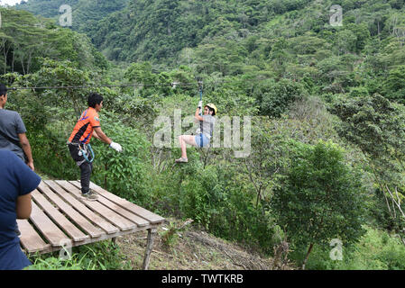 Junín, Peru - Dec 31, 2018: Abenteuerliche Touristen ziplining über einen Fluss in der Region Chanchamayo Stockfoto