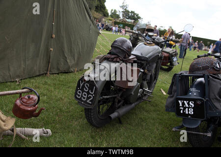 Zwei Militär Motorräder außerhalb ein Zelt, ein Blue Royal Enfield Motorrad und einem grünen BSA M20 Motorrad auf der militärischen Veranstaltung geparkt Stockfoto