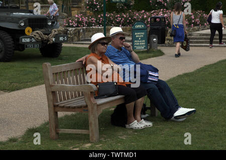 Edenbridge, Kent, Großbritannien - älteres Paar draußen sitzen auf einer Bank sitzen können und die Welt sehen, in der Sie tagsüber an einem sonnigen Tag Stockfoto