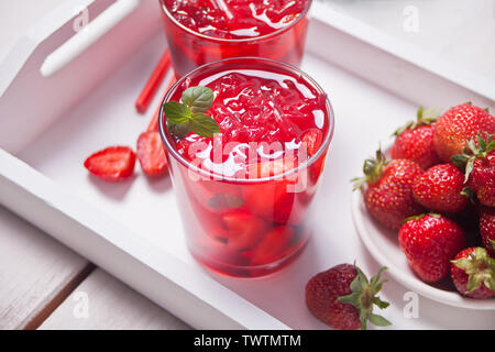 Gläser mit frischen, hausgemachten Erdbeere süß Eistee oder Cocktail, Limonade mit Minze. Erfrischenden kalten Getränk und Platte mit Erdbeere auf dem w Stockfoto