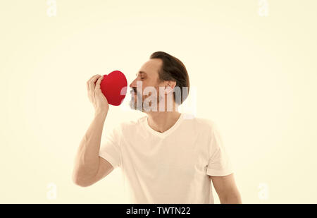 Man bärtige Hipster halten Herz. Romantischer Kerl verlieben. Gruß aus ehrlichem Herzen. Valentines Tag feiern. Liebe und romantische Gefühle Konzept. Herz-Attribut von Valentine. Herz Geschenk präsentieren. Stockfoto
