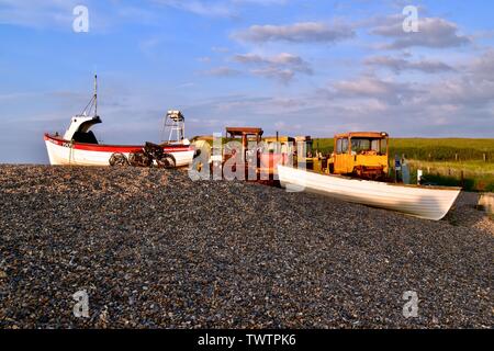 Boote, Traktoren und Reusen in der untergehenden Sonne auf weybourne Strand. Stockfoto