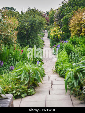 Grenzen bersten mit Sommer blühende Pflanzen, die eine lange Garten Weg. Stockfoto