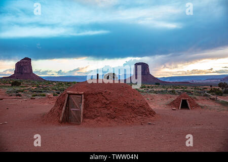 Das Monument Valley, Navajo Hogan, typische Häuser am roten Felsen und blauen bewölkten Himmel Hintergrund. Navajo Tribal Park in der arizona-utah Grenze, United States Stockfoto