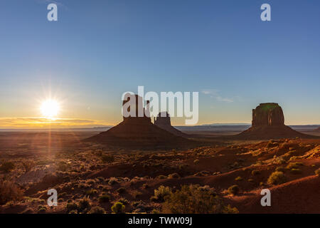 Monument Valley bei Sonnenaufgang. Navajo Tribal Park in der arizona-utah Grenze USA. Sonne hinter den roten Felsen, klaren Himmel Hintergrund Stockfoto