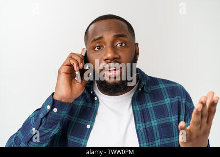 Mann in Papiertüte auf dem Kopf angezeigt mit Zeigefinger auf weißem Hintergrund. Stockfoto