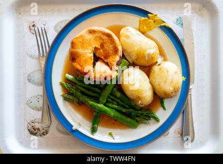 Lecker Yorkshire essen Steak pie mit neuen Kartoffeln Spargel Sauce, Senf und blauen Platte auf einem Tablett umrandete Stockfoto