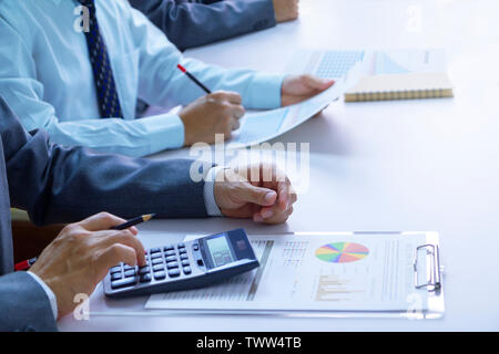 Geschäftsleute in einem Konferenzraum sind zutiefst Überprüfung der Abschlüsse und Berichte für einen Return on Investment oder Investitionen Risikoanalyse. Stockfoto