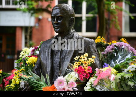 Alan Turing Statue mit Blumen Stockfoto