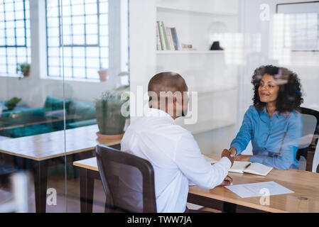 Lächelnd Office Manager Händeschütteln mit einem Mitarbeiter Stockfoto