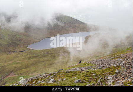 Wanderer, die über Lochan Meall auf dem Aufstieg auf den Gipfel des Ben Nevis in den Highlands von Schottland Großbritannien auf einem in der Regel bewölkter Tag Stockfoto