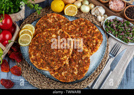 Die traditionelle türkische Küche: Lahmacun türkische Pizza mit Hackfleisch/Faschiertes Rindfleisch oder Lamm Fleisch, Paprika, Tomaten, Kreuzkümmel Spice, auf rustikalen Holztisch ba Stockfoto