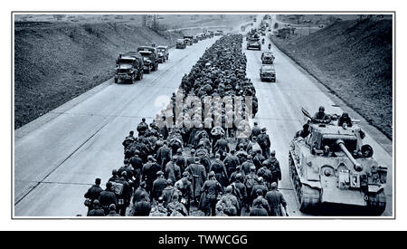 WW2 Massengruppe von Kriegsgefangenen der deutschen Nazi-Armee auf der deutschen Autobahn 04. Mai 1945, Deutschland Tausende deutsche Gefangene marschieren auf einer modernen deutschen Autobahn entlang, während die amerikanischen Streitkräfte mit Panzern, Lastwagen und Jeeps vorwärts drängen. 4.Mai 1945. Stockfoto