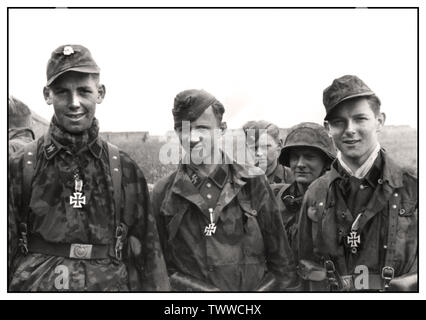 WW2 WAFFEN-SS-EISENKREUZMEDAILLEN Nazi-Propagandabild junger deutscher Waffen-SS-Männer mit neu ausgezeichneten Eisernen Kreuz-Medaillen auf dem Feld an der Invasionsfront bei Caen drei junge Männer der Waffen-SS nach der Verleihung des Eisernen Kreuzes II 1944 Caen France Stockfoto