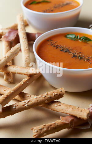 Tomate creme Suppe und Brot Sticks mit Schinken Stockfoto