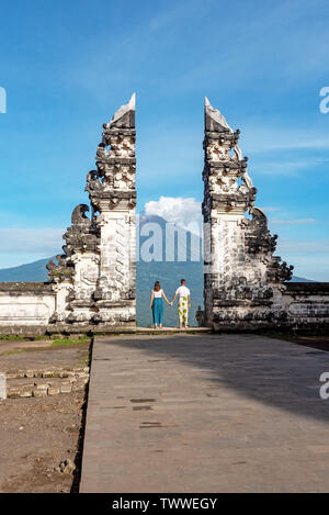 Nicht identifizierte Ehepaar am Gate bei Pura Lempuyang Luhur mit Herrn Agung vulkanischen, heilige Hinduismus Tempel auf Bali, Indonesien. Stockfoto