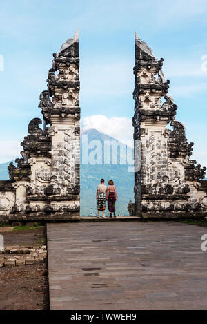 Nicht identifizierte Ehepaar am Gate bei Pura Lempuyang Luhur mit Herrn Agung vulkanischen, heilige Hinduismus Tempel auf Bali, Indonesien. Stockfoto