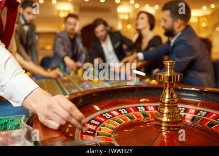 Der Croupier hält eine Kugel in einem Casino in seiner Hand. Das Spielen in einem Casino. Stockfoto