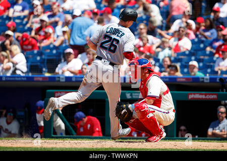 Philadelphia, Pennsylvania, USA. 23. Juni 2019. Miami Marlins erste Basisspieler Garrett Cooper (26) kommt in die Kerbe auf seinem Haus ausführen als Philadelphia Phillies catcher Andrew Knapp (15) sieht in der MLB Spiel zwischen den Miami Marlins und Philadelphia Phillies am Citizens Bank Park in Philadelphia, Pennsylvania. Christopher Szagola/CSM/Alamy leben Nachrichten Stockfoto