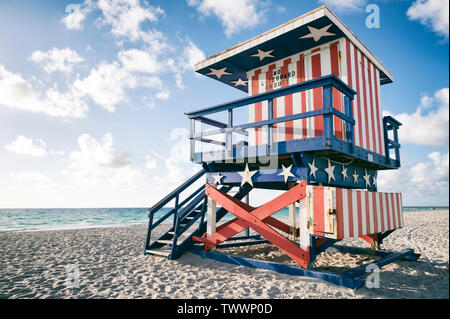 Classic rot, weiß und blau American Flag themed lifeguard Tower, jetzt im Ruhestand, auf dem Sand in South Beach, Miami, Florida, USA Stockfoto