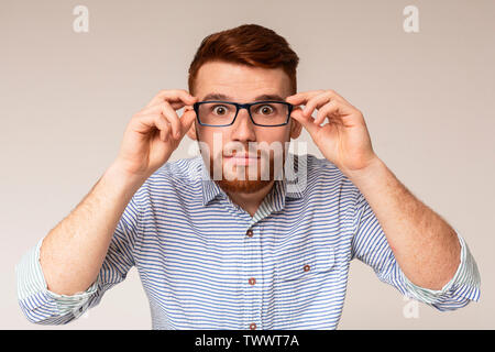 Jungen Mann, seine großen Augen zeigt, in Gläser Stockfoto