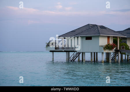 Schöne isoliert Luxus Bungalows am Wasser Malediven in der Blue Green Ocean der Malediven auf dem Sunset Stockfoto