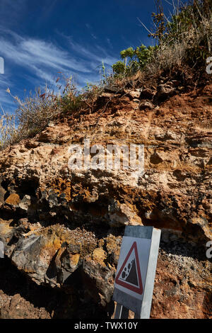 Klippe mit steinschlag Zeichen mit blauem Himmel entlang der Frente Mar in Funchal, Madeira, Portugal, Europäische Union Stockfoto