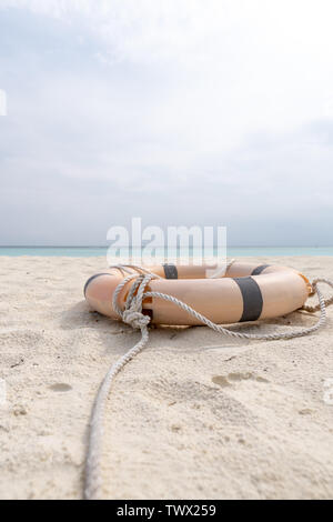 Rettungsring und Seil am Strand liegen an einem tropischen Strand. Stockfoto