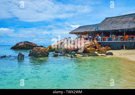 PHUKET, Thailand - Mai 1, 2019: Der alte Holzhütte am Ufer des Khai Nai Island Nachbarn mit der riesige Felsbrocken und Felsen, am 1. Mai auf Phuket Stockfoto