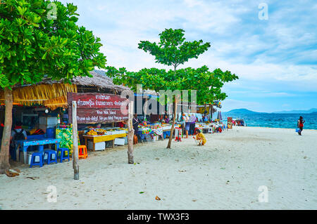 PHUKET, Thailand - Mai 1, 2019: Der weiße Sandstrand von Khai Nok Insel mit einer Linie aus Holzhütten der lokalen Cafes, am 1. Mai auf Phuket Stockfoto