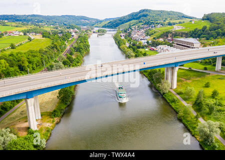 Eine Freizeit Boot unter hohen Brücke, wo Autobahn A13 entspricht 8 Autobahn über die Mosel. Luftbild des Schengener Stadtzentrum. Dreiländereck vor den Grenzen der Lu Stockfoto