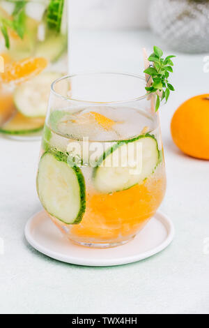 Kaltes Getränk mit Gurke und Mandarin am weißen Hintergrund. Konzept der Sommer trinken Stockfoto