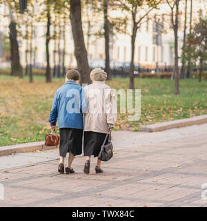 Zwei unkenntlich älterer Frauen zusammen zu Fuß in die Stadt, Rentner. Herbst, Zeit, Interessen, Alter, Lebensstil und Freundschaft Stockfoto