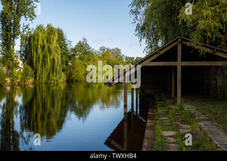 Schöne Reflexion der Bäume auf einem Fluss in der Bretagne, Frankreich, mit einem alten Bootshaus auf der Seite Stockfoto