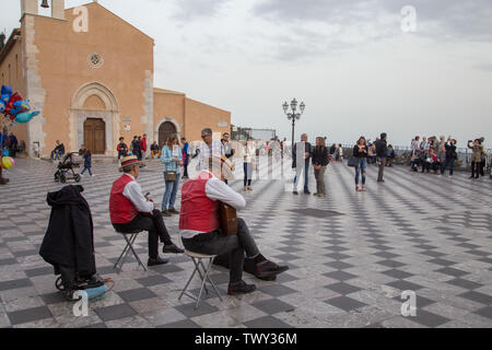 Taormina, Italien - 17. März 2018: Straßenmusiker spielen an der Piazza IX Aprile, beliebte Touristenattraktion. Stockfoto