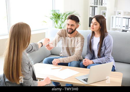 Real estate agent Einen Schlüssel von neuen Haus junges Paar Stockfoto