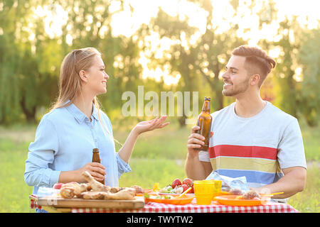 Junges Paar mit Picknick im Freien auf Sommer Tag Stockfoto