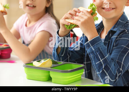 Schüler mit Mittagessen im Klassenzimmer Stockfoto