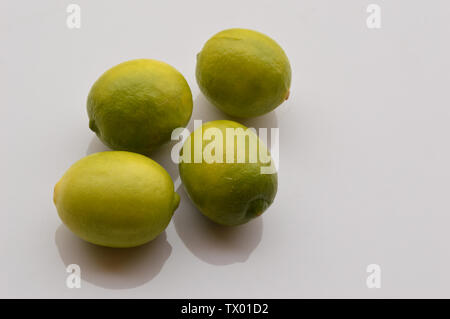 Frische reife Limetten, ganze Limes, Bündel grüne frische Zitronen auf weißem Hintergrund. Stockfoto