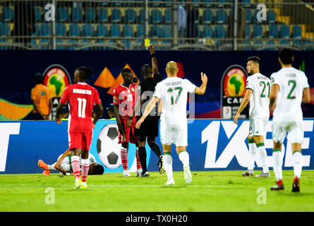 Kairo, Ägypten. 23. Juni 2019. Philemon Otieno (3 L) von Kenia ist eine gelbe Karte während der Fußball-Afrikameisterschaft 2019 Gruppe C Match zwischen Algerien und Kenia in Kairo, Ägypten, am 23. Juni 2019 gezeigt. Algerien gewann 2-0. Credit: Li Yan/Xinhua/Alamy leben Nachrichten Stockfoto