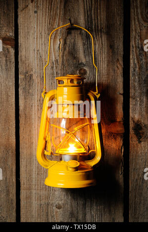 Die alte Petroleum Laterne hängend an der hölzernen Wand Stockfoto