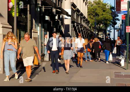 Menschen, die an einem warmen Sommernachmittag zur Sommersonnenwende am 21. Juni 2019 die W 23rd St im Flatiron District von Manhattan, New York City, entlang gehen Stockfoto