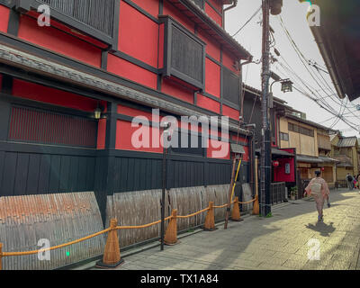 Kyoto, Japan - April 2019: Frau im traditionellen Kimono Spaziergänge in einer engen Straße im Stadtteil Gion von Kyoto Stockfoto